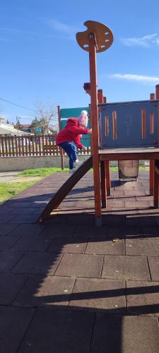 a child on a slide at a playground at Maria's home in Órmos
