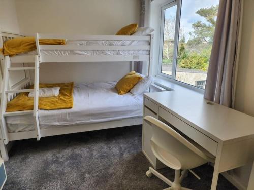 a bedroom with two bunk beds and a desk at Panorama House, Luxury 2-Bedroom Apartment 2 in Kidlington