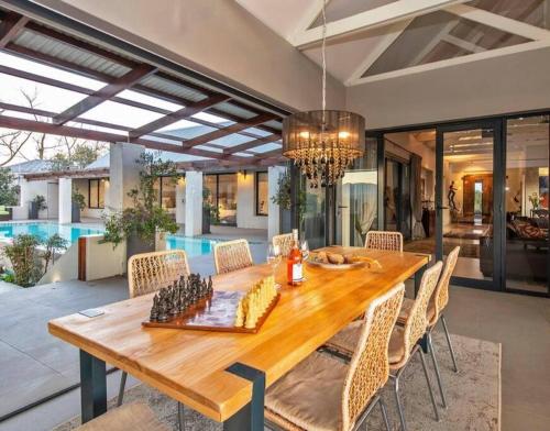 a dining room with a wooden table and chairs at Majestic Elgin Farm House in Mispah