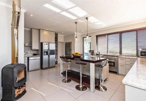 a kitchen with a stove and a kitchen with a fireplace at Majestic Elgin Farm House in Mispah