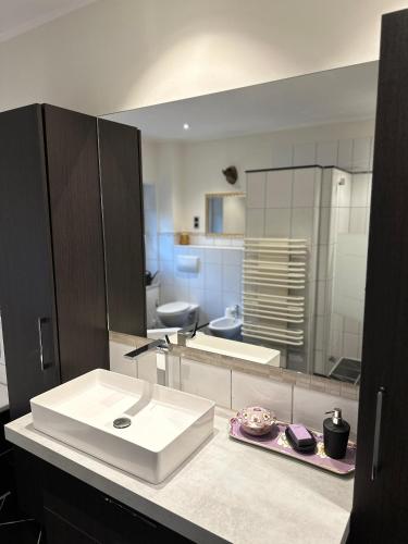 a bathroom with a white sink and a mirror at Xantener Ferienhaus Heeser Weg in Xanten