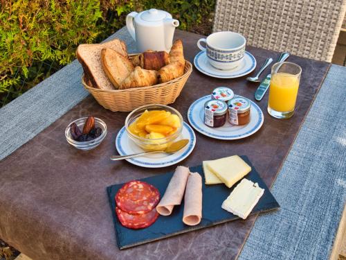 a picnic table with bread and a basket of food at Hôtel des Roches - Climatisation in Les Eyzies-de-Tayac