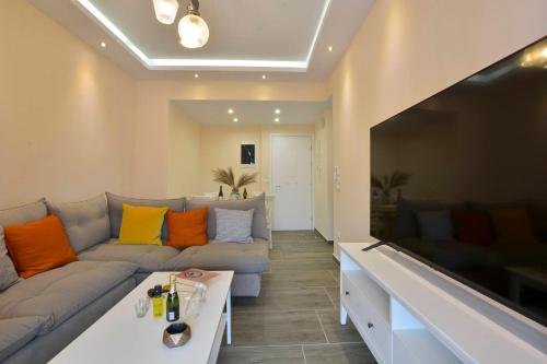 a living room with a couch and a large flat screen tv at Saroko House in Corfu