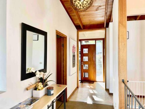 um corredor com um espelho e uma mesa com flores em The Beautiful Grand Terrace (Seaview) em Mount Martha