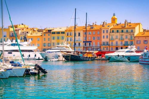 a group of boats docked in a harbor with buildings at Les Restanques rez jardin 2063 in Grimaud