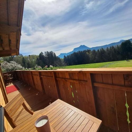 a wooden deck with a bench and a view of the mountains at Landhaus Stadlmann in Thalgau