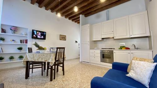 eine Küche mit einem Tisch und einem blauen Sofa in der Unterkunft City Apartments Rialto Market in Venedig