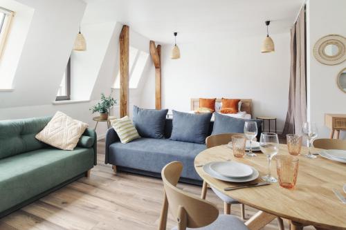 a living room with a blue couch and a table at Manpro Apartments Toruń in Toruń