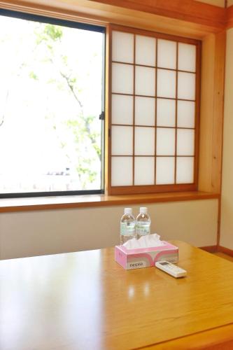 a table with two bottles of water and a book at 湯布院我楽珍民泊Yufuin Garakuchin in Yufuin