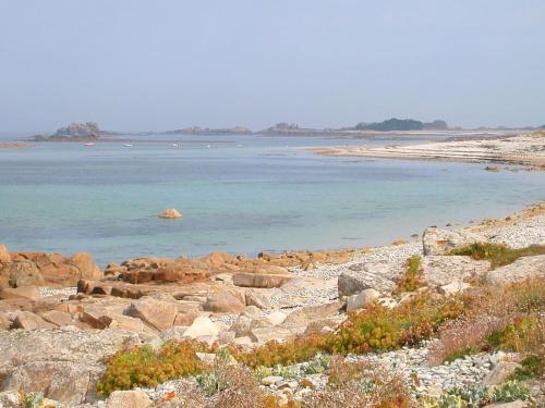 a large body of water with rocks and the ocean at Amour Amour Love Room in Penvénan