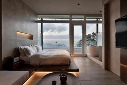 a bedroom with a bed and a large window at Daybreak in Jiufen