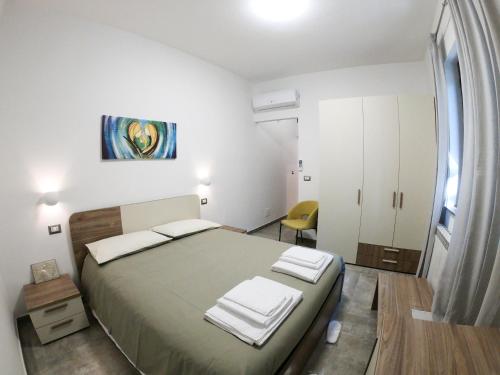 a bedroom with a large bed and a yellow chair at B&B Tenuta Piano Campo in Ucria