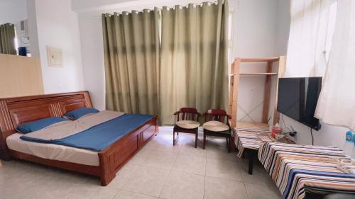 員林的住宿－阿布の家，一间卧室配有一张床、两把椅子和电视