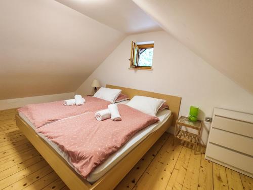 a bedroom with a bed with two towels on it at Silent Orchard in Naklo