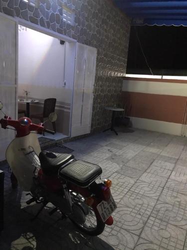 a motor scooter parked in a room with a table at Nhà Nghỉ Năm Bé in Xuyên Mộc