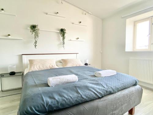 a bedroom with a large bed with two towels on it at City Home Finland Penthouse – SAUNA & Best Location in Tampere