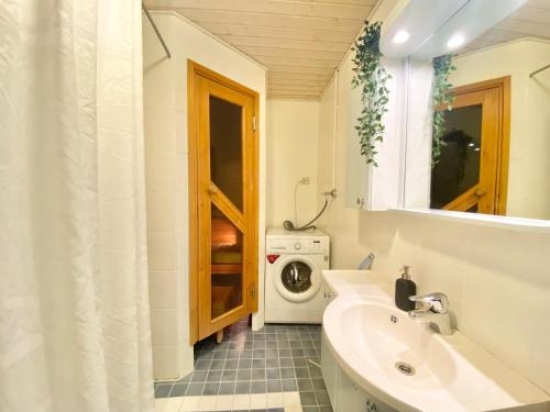 a bathroom with a sink and a washing machine at City Home Finland Penthouse – SAUNA & Best Location in Tampere