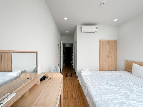 a bedroom with two beds and a mirror at AQUA Seaview Hotel in Nha Trang