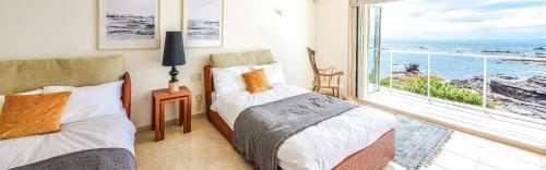 a bedroom with two beds and a view of the ocean at The House Moroiso secret beach in Miura