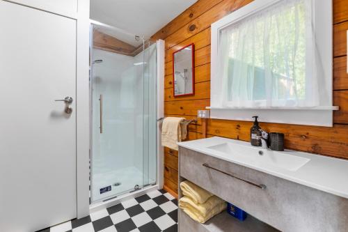 a bathroom with a sink and a glass shower at Lakeside Lookout - Lake Tarawera Holiday Home in Lake Tarawera