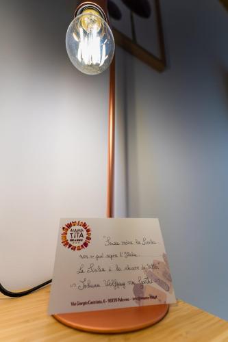 a letter sitting on top of a table with a light at Mama Tita Rooms and Breakfast in Palermo