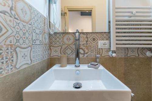 a bathroom with a sink and a mirror at Mama Tita Rooms and Breakfast in Palermo