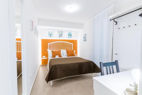 a bedroom with a bed with an orange headboard at Mama Tita Rooms and Breakfast in Palermo