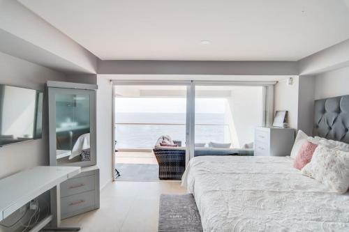 a bedroom with a bed and a view of the ocean at Harbor 9005 Beachfront 2bdr by Moikkarentals in Puerto Vallarta