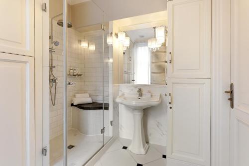 a white bathroom with a sink and a shower at Downtown Apartments Sopot Jagiełły in Sopot