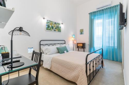 a bedroom with a bed and a desk in it at Mama Tita Rooms and Breakfast in Palermo