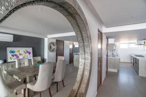 a dining room with a table and white chairs at Harbor 9005 Beachfront 2bdr by Moikkarentals in Puerto Vallarta