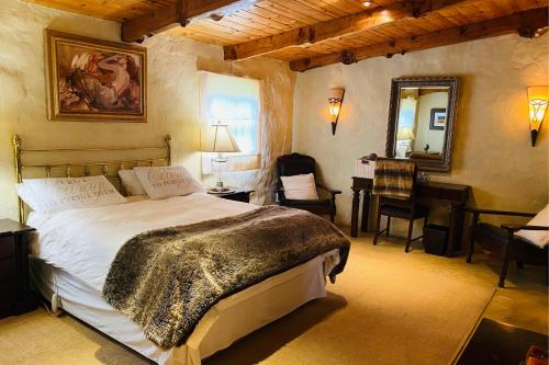 um quarto com uma cama, uma secretária e um espelho em Stonehaven Cottage em Machadodorp