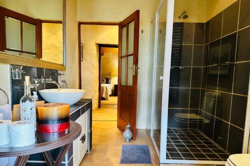 a bathroom with a sink and a shower at Stonehaven Cottage in Machadodorp