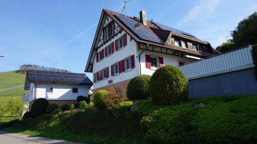 una casa blanca con techo solar en una colina en Ferienwohnung Anna Durbach, en Durbach