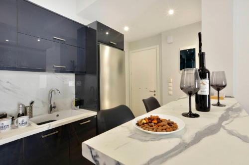 a kitchen with a table with a bowl of fruit and wine glasses at Saroko Studio in Corfu