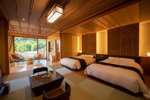a hotel room with two beds and a desk and a room at Hanayashiki Ukifune-en in Uji