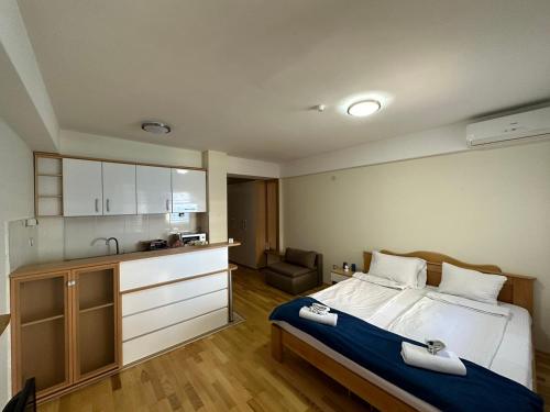 a bedroom with a large bed and a kitchen at Park Diamond Apartments in Ohrid