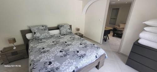 um quarto com uma cama com um edredão preto e branco em maison calme et spacieuse em Bassens