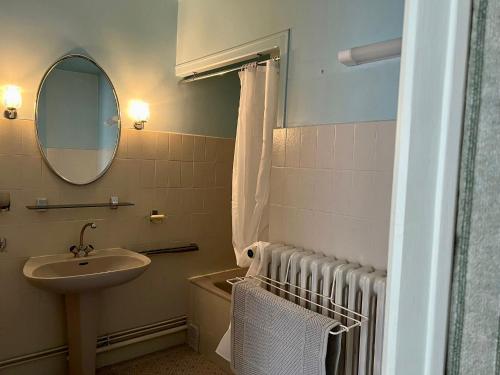 La salle de bains est pourvue d'un lavabo et d'un miroir. dans l'établissement Appart patio véranda terrasse , à Arbois