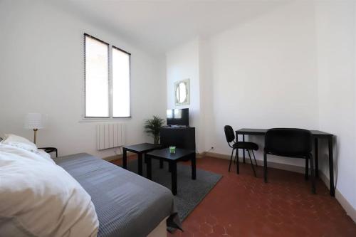 a bedroom with a bed and a table and chairs at Studio boulevard Schloesing in Marseille