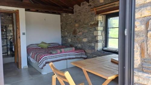 una camera con letto e tavolo in legno di Peaceful Stone House with Nature View in Karaburun a Smirne