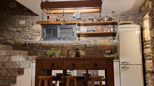 a kitchen with a white refrigerator and a counter at Peaceful Stone House with Nature View in Karaburun in Izmir