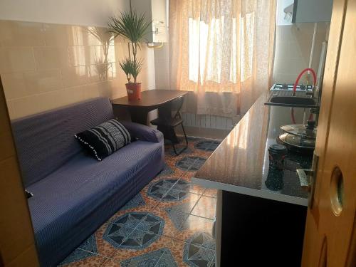 a living room with a purple couch in a kitchen at Garsoniera in Dorohoi