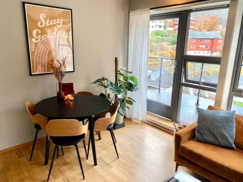 a living room with a table and chairs and a window at Top floor apartment with mountain view, terrace 22sqm, free parking in Bergen