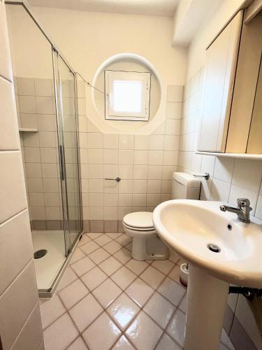a bathroom with a toilet and a sink and a shower at Genova 9 in Grado