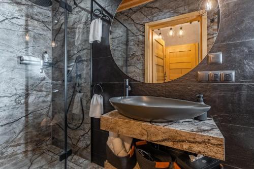 y baño con lavabo y espejo. en Góralska Domina Ville Premium, en Zakopane