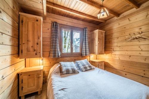 a bedroom with a bed in a log cabin at Chalet Nid Zut in Châtel
