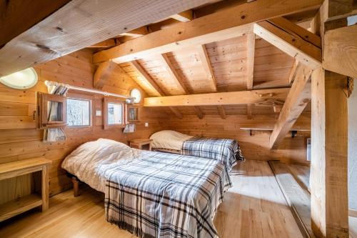 two beds in a room in a log cabin at Chalet Nid Zut in Châtel