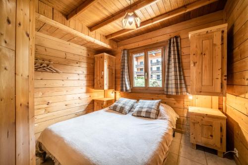 シャテルにあるChalet Nid Zutの木造キャビン内のベッド1台が備わるベッドルーム1室を利用します。
