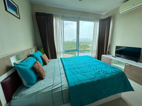 a bedroom with a blue bed with a large window at The Ozone Krabi Condotel in Krabi